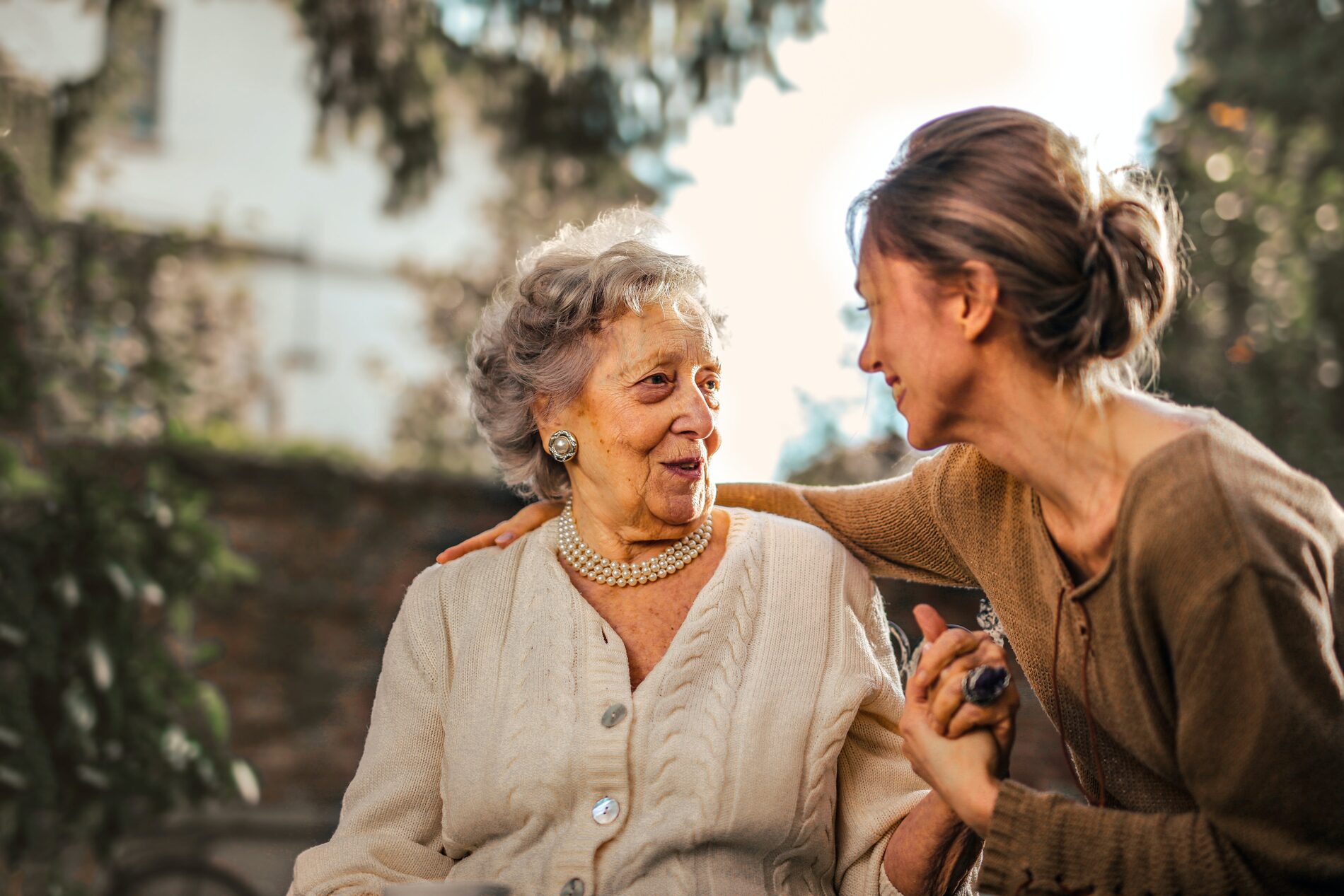 A family caregiver and an older woman sharing a warm moment at home