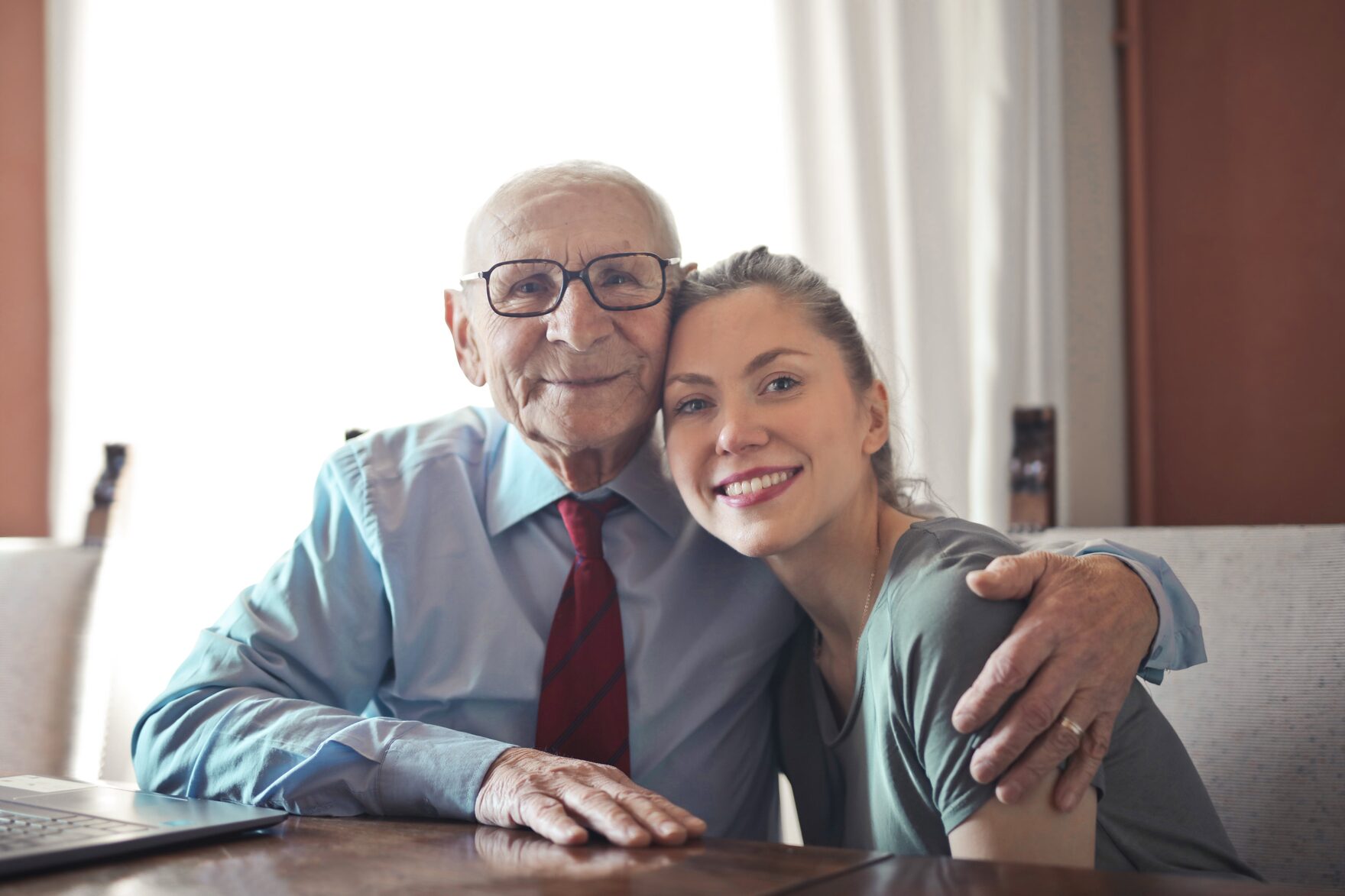 A woman and her father sharing a warm moment at home